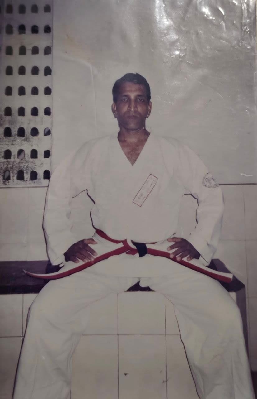 Informal portrait of instructor seated in karate gi
